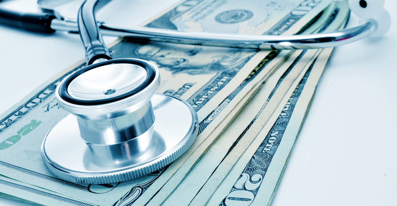 a stethoscope on a pile of US dollar bills, depicting the health care industry concept
